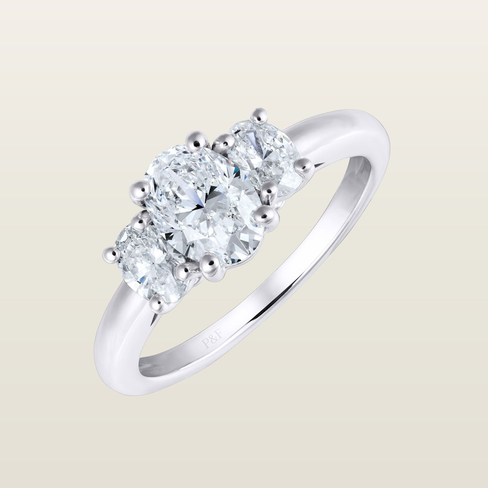 Bague Trilogie en or blanc 18 carats sertie d’un diamant central taille ovale encadré de deux diamants latéraux, monture trois pierres.