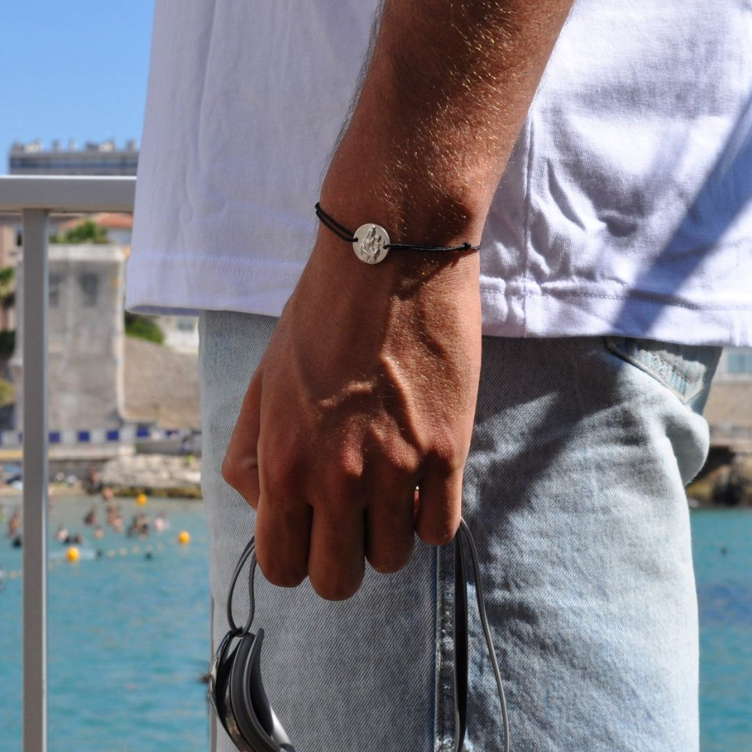 homme qui porte le bracelet notre dame de la garde en argent sur un cordon noir 