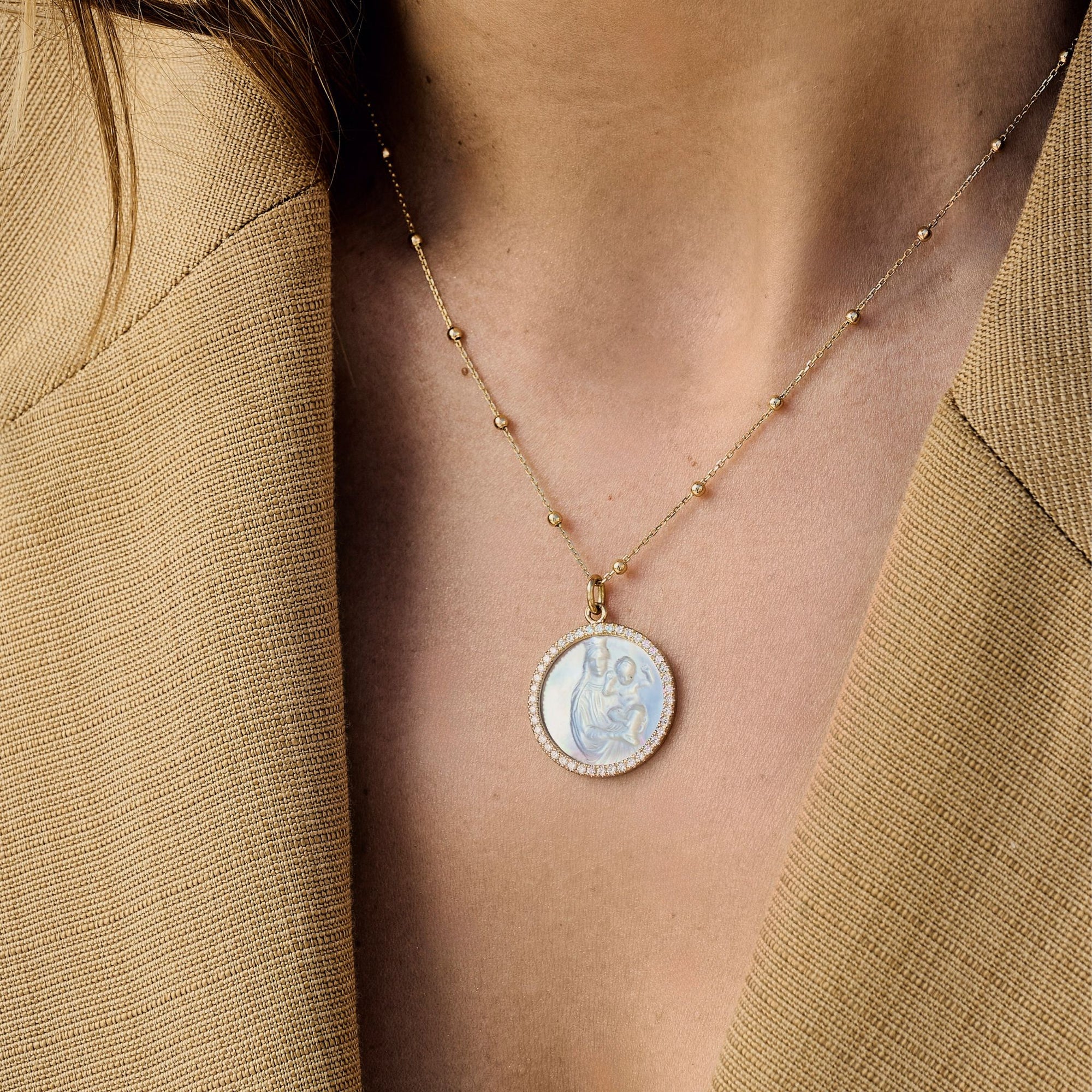 médaille en nacre et diamants sur une chaîne en or jaune