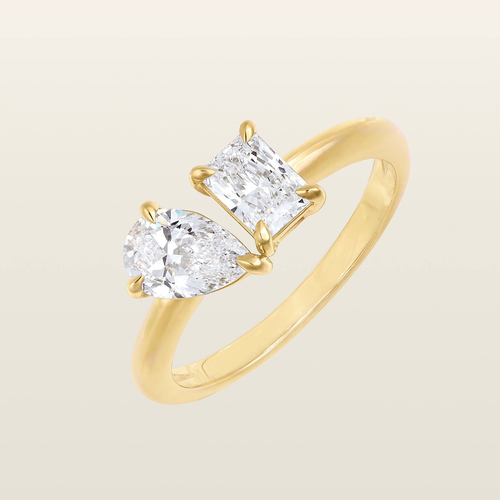 Bague Toi & Moi en or jaune sertie de deux diamants, un taille poire et un taille radiant, montés face à face sur un anneau fin
