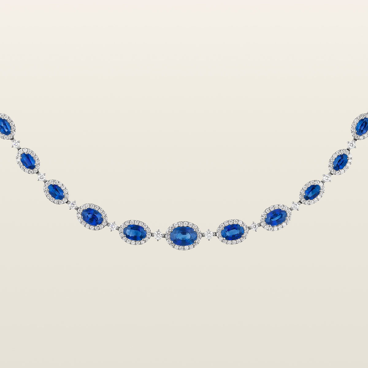 Gros plan sur le centre du collier Rivière saphirs et diamants, saphirs ovales bleus entourés de diamants
