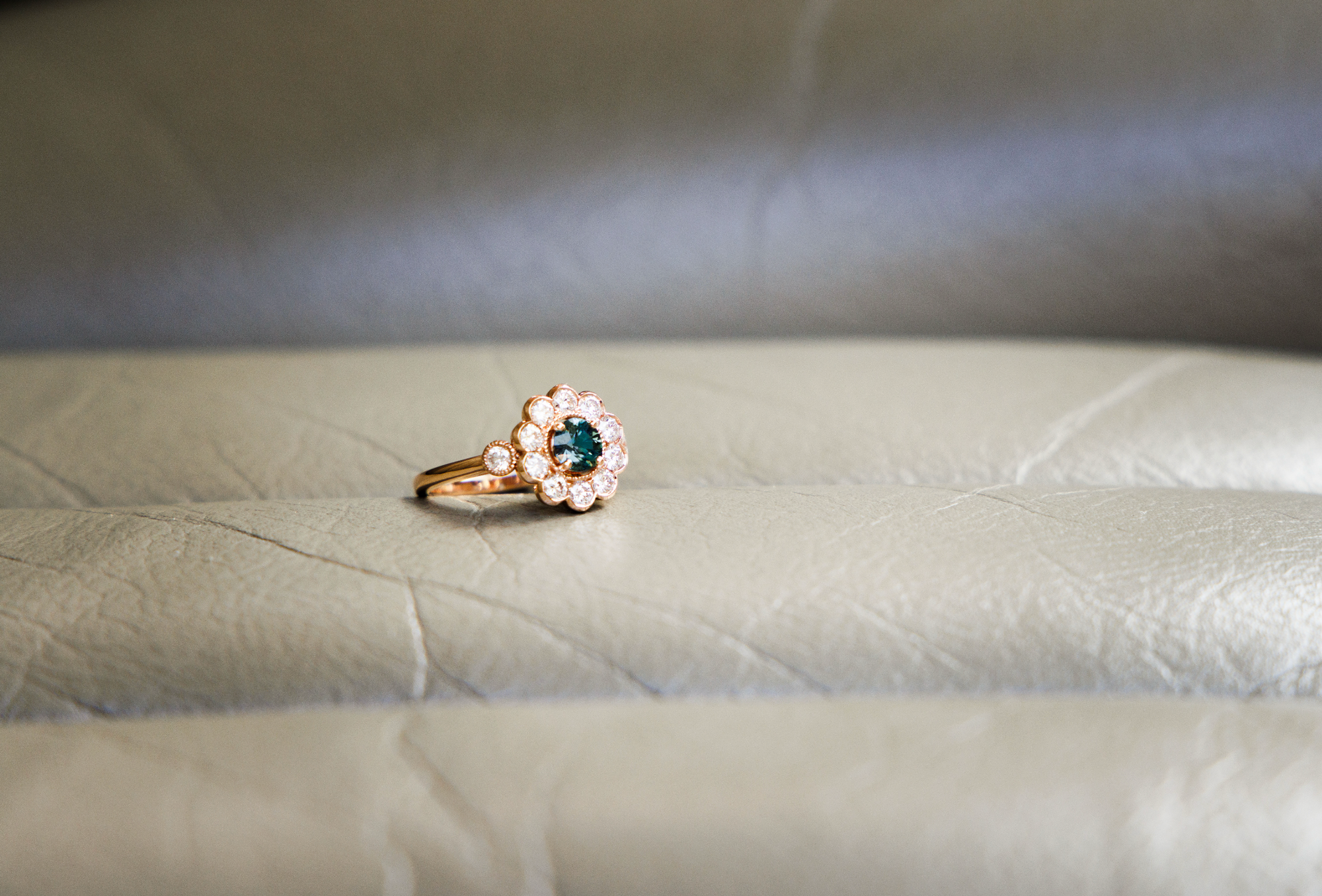 bague diamant naturel et saphir vert posé sur un coussin 