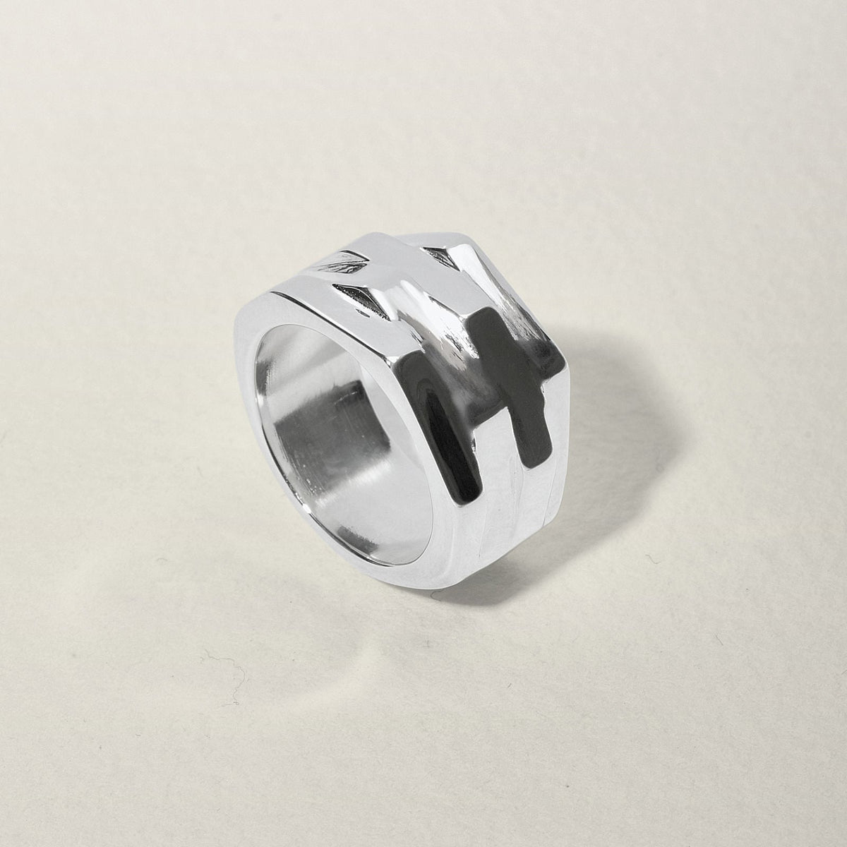 bague en argent motif ecrou posé sur une table 