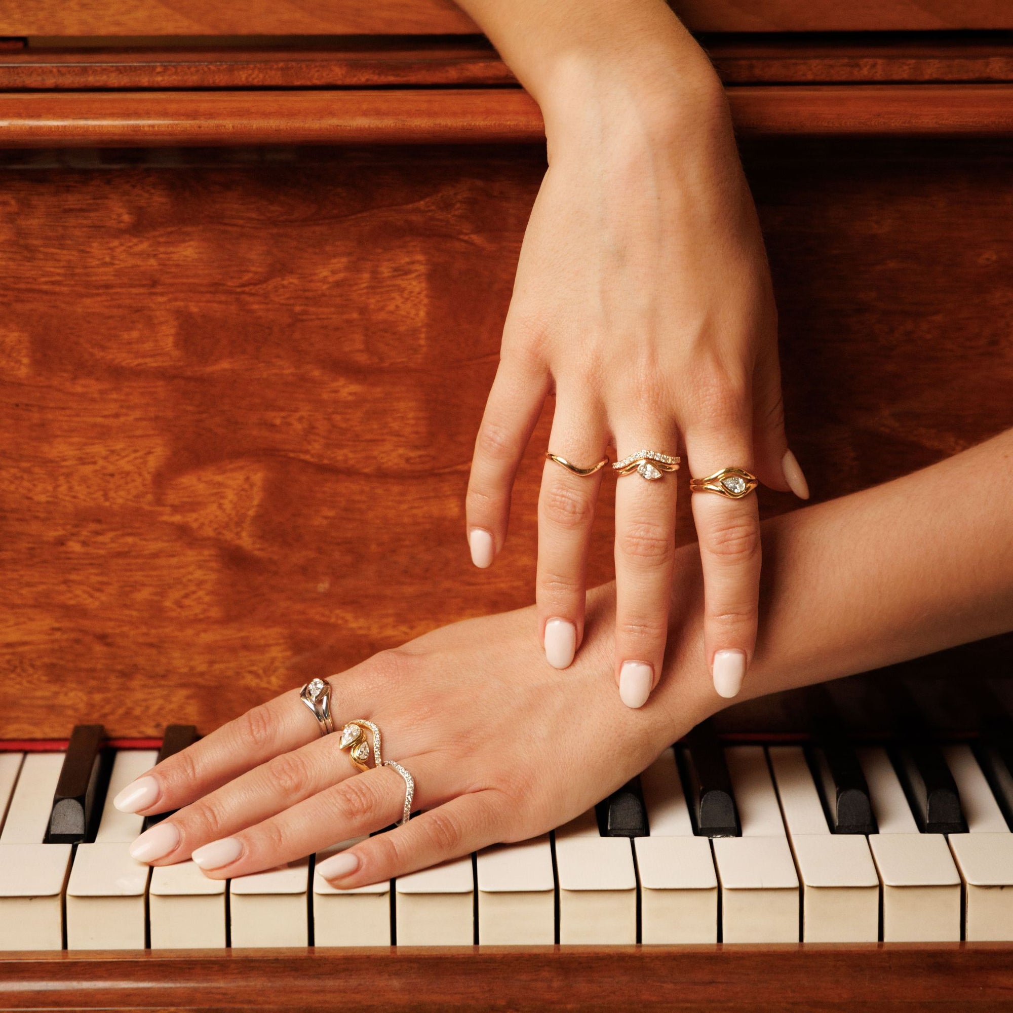 deux mains de femme qui porte bagues et alliances diamants naturels sur un piano