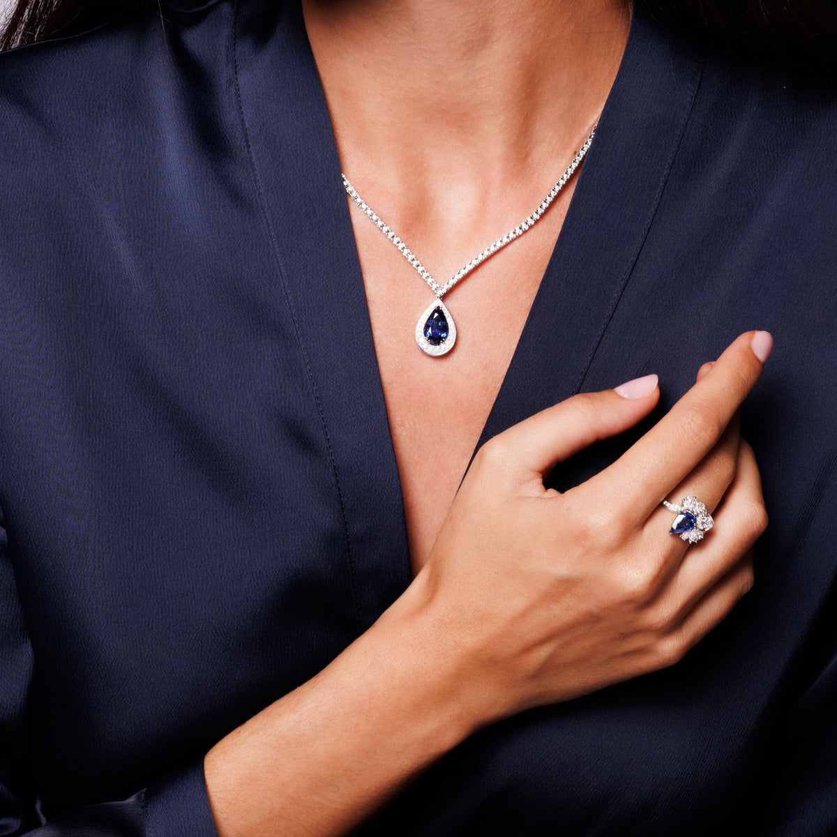 femme qui porte un collier haute joaillerie et une bague haite joaillerie avec un saphir et un diamant naturel 