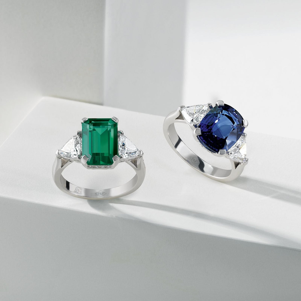 deux bagues trilogie une avec un saphir bleu et une avec une emeraude verte 