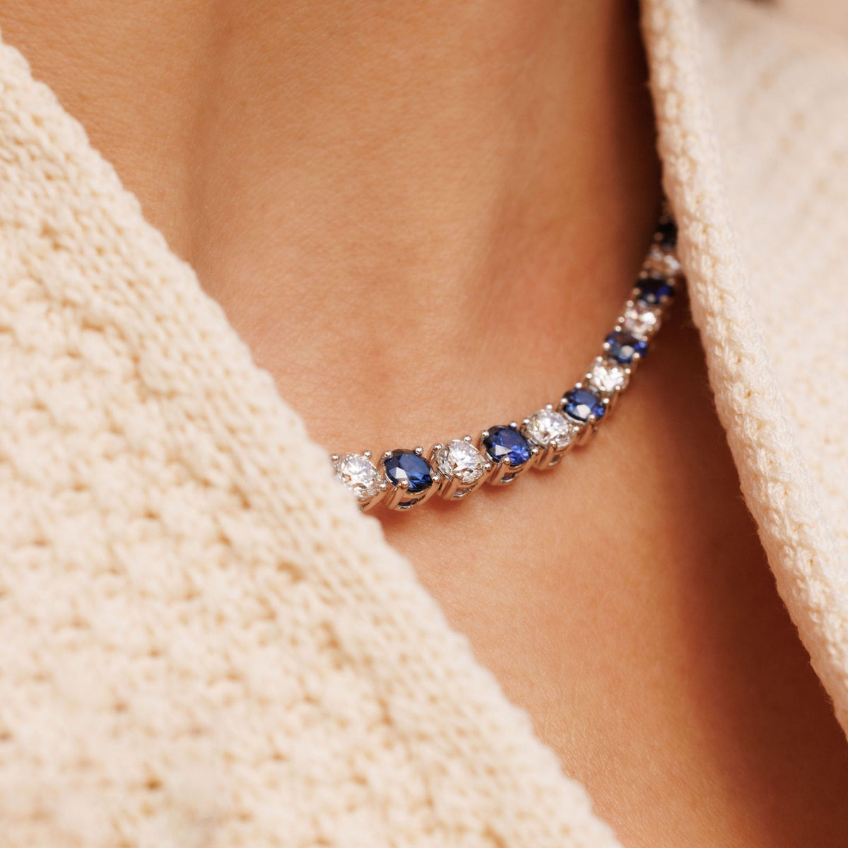 femme qui porte autour de son cou une riviere bleuet saphirs et diamants