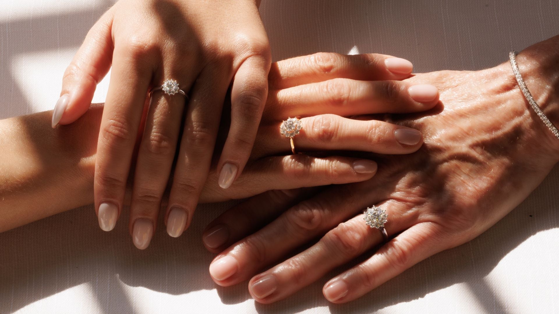 trois mains de femmes qui portent des bagues margurites diamants naturels 
